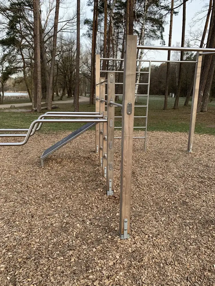 Calisthenics-Anlage mit Reck, Leiter und Barren auf Holzschnitzeln